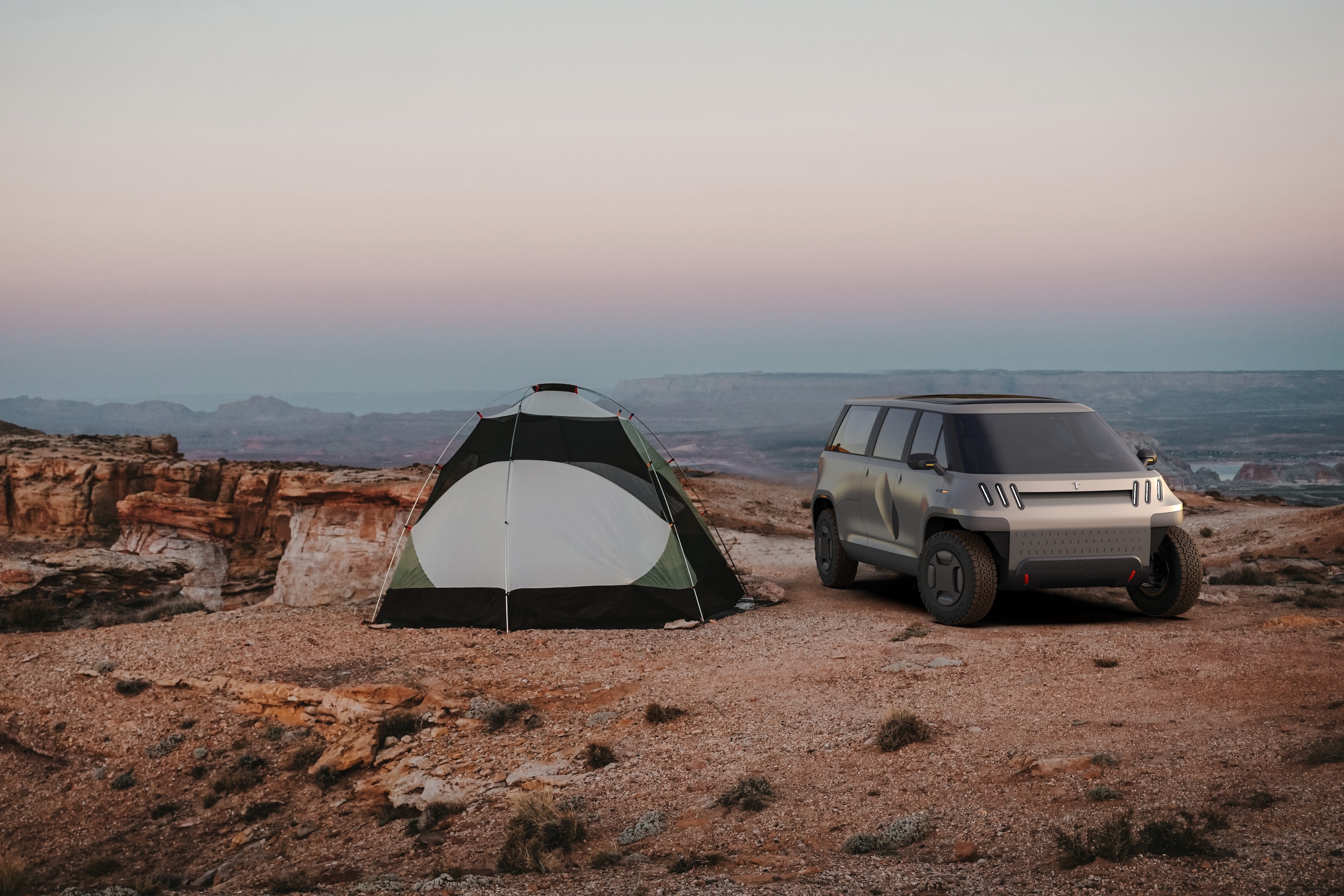 TELO truck parked beside a green tent with the Grand Canyon in the background at sunset.